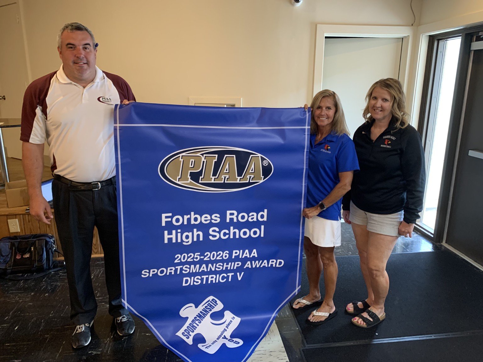 Forbes Road High School representatives holding a PIAA Sportsmanship Award banner